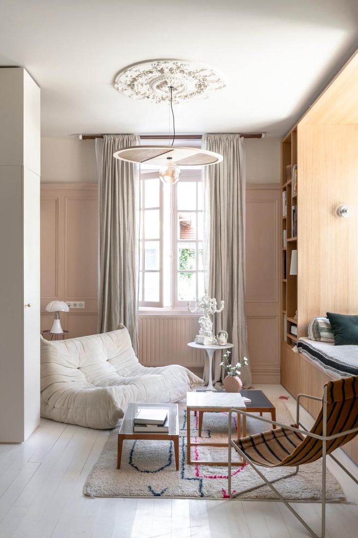 Salon aux boiseries rose poudré, canapé Togo écru, bibliothèque en chêne — Maison Lehmann