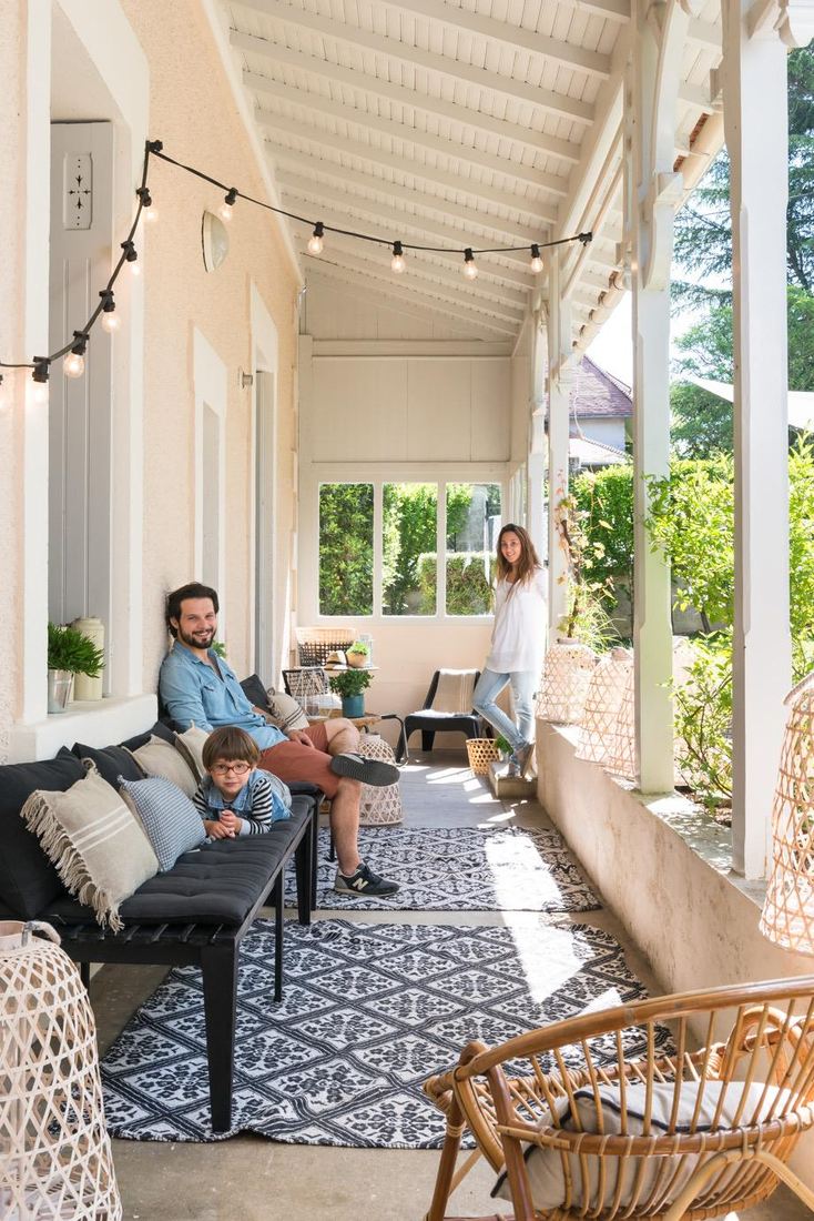 La famille sous la véranda, guirlande d'ampoules et rotin — première vie de la Maison Lehmann