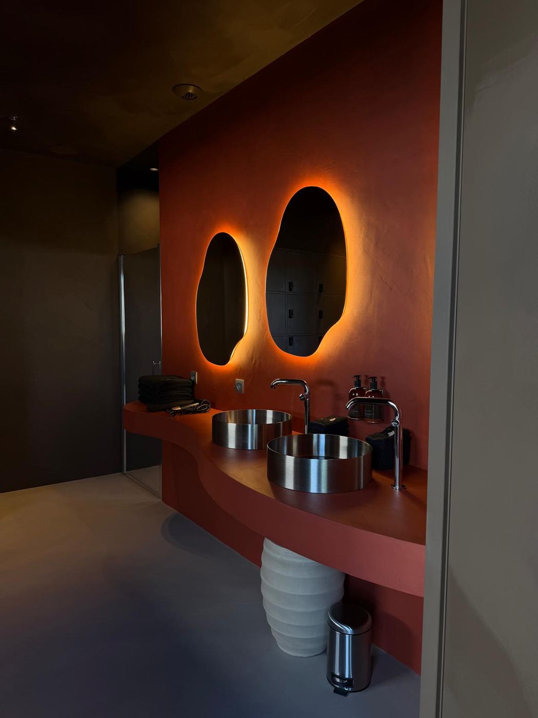 Salle d'eau terracotta, deux miroirs organiques halo orange — Studio Clo