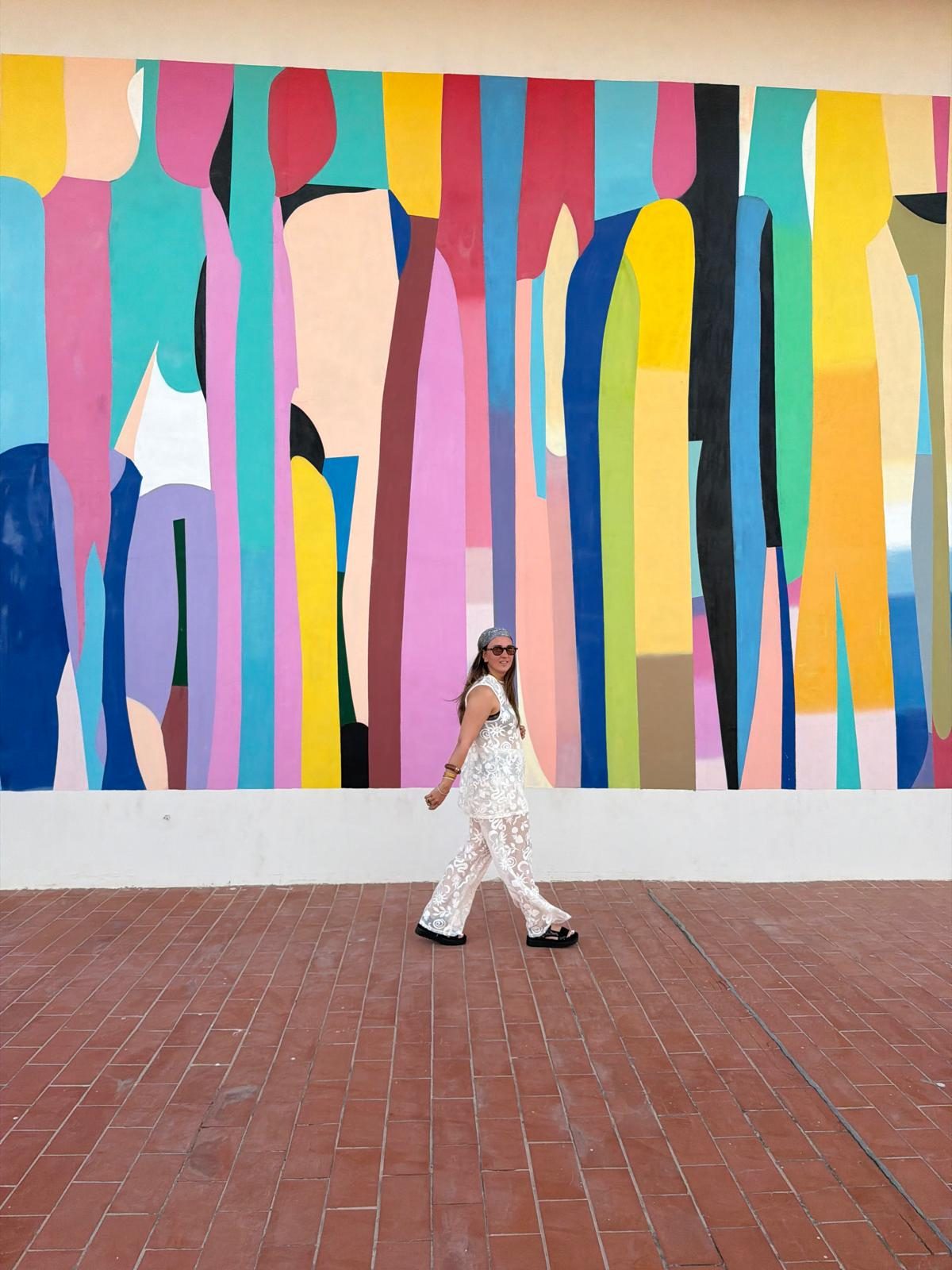 Loanah marchant devant une fresque murale multicolore