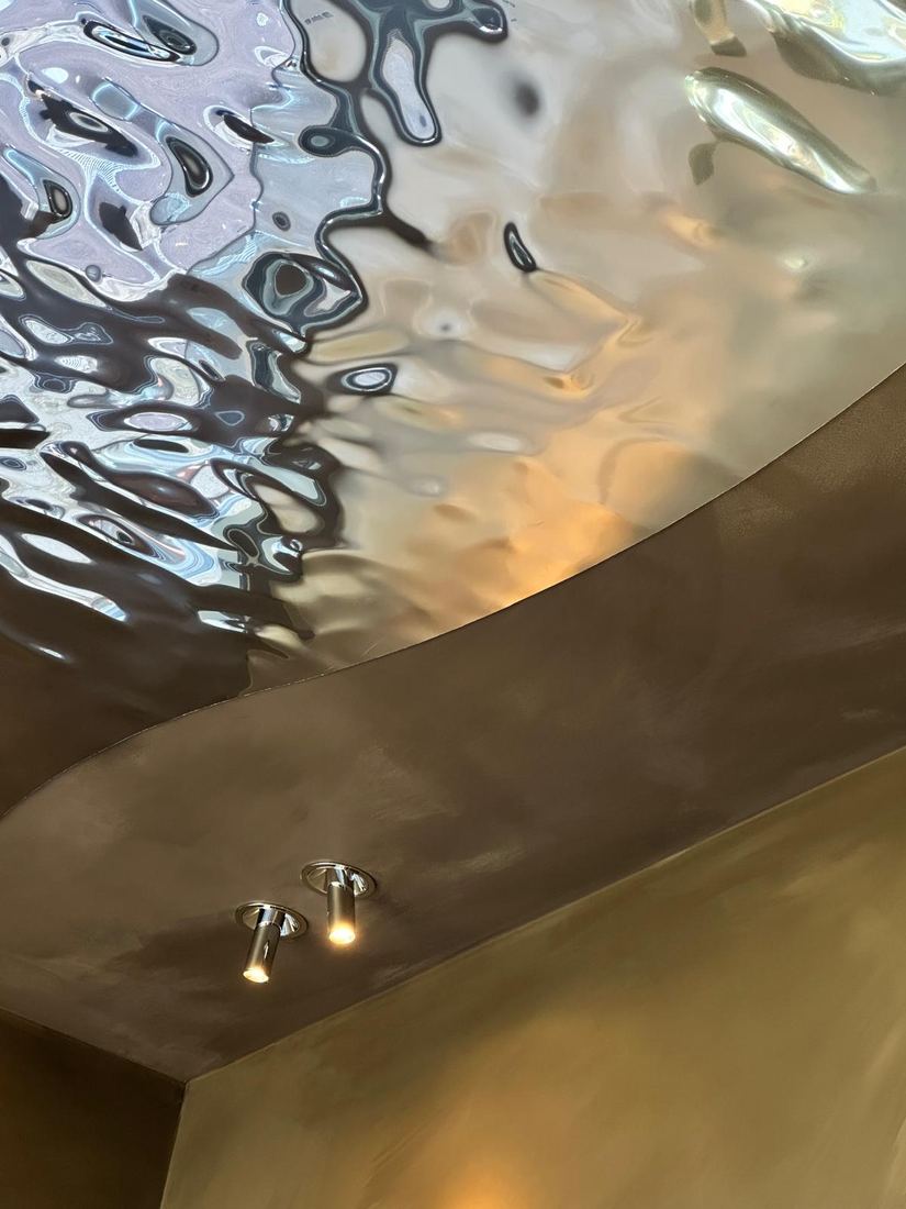 Plafond en acier ondé réfléchissant la lumière chaude — Studio Clo