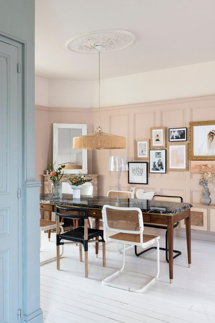 Salle à manger, boiseries roses, table en marbre noir, mur de cadres — Maison Lehmann
