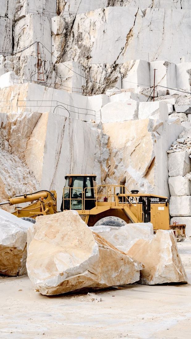 Carrière de marbre de Carrare, blocs bruts et chargeuse jaune